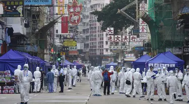 Penyelidik pemerintah yang mengenakan pakaian pelindung berkumpul di daerah Yau Ma Tei di Hong Kong, Sabtu (23/1/2021). Ribuan warga Hong Kong diperintahkan tetap tinggal di rumah setelah otoritas setempat memberlakukan penguncian ( lockdown ) untuk pertama kalinya sejak pandemi COVID-19 merebak. (A