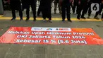Sejumlah massa simpatisan Partai Buruh dan beberapa serikat buruh membentangkan spanduk saat melakukan demo di depan Balai Kota DKI Jakarta, Selasa (28/11/2023). Mereka meminta kenaikan Upah Minimum Provinsi (UMP) 2024 sebesar 15 persen. (Liputan6.com/Herman Zakharia)
