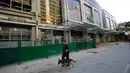 Petugas bersama anjing pelacak melewati area hotel yang berasap di kompleks Resorts World Manila, Jumat (2/6). Serangan pria bersenjata dilaporkan telah melukai puluhan tamu hotel dan kasino yang berlarian setelah penembakan muncul (AP Photo/Aaron Favila)