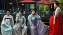 Empat wanita berpose mengenakan kostum Dinasti Tang saat mengunjungi Danau Barat di Hangzhou di provinsi Zhejiang timur China (31/3). Bahan pakaian Dinasti Tang terbuat dari sutra dan terkenal karena kelembutan dan ringan.  (AFP Photo/China Out)