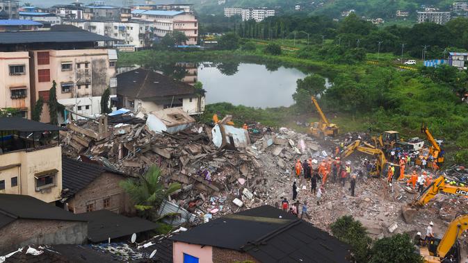 Suasana pencarian korban di reruntuhan gedung apartemen yang runtuh di Mahad, India (25/8/2020). Sedikitnya 50 orang terjebak dalam semalam di dalam apartemen yang runtuh tersebut. (AFP Photo/Punit Paranjpe)