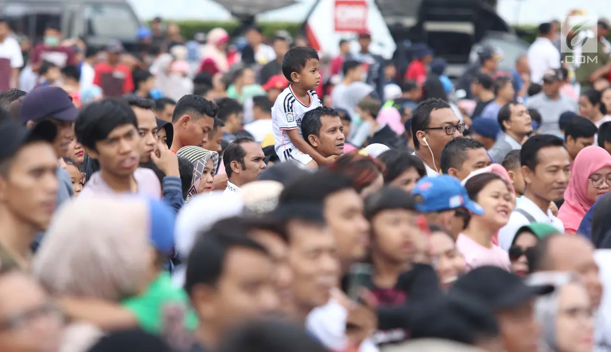 Seorang anak dibopong saat menyaksikan peresmian pengoperasian Moda Raya Terpadu Jakarta fase 1 di Kawasan Bundaran HI, Jakarta, Minggu (24/3). Peresmian dilakukan oleh Presiden Joko Widodo, Gubernur DKI Jakarta, Anies Baswedan serta pihak terkait. (Liputan6.com/Helmi Fithriansyah)