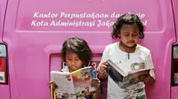 Anak-anak membaca buku yang disediakan perpustakaan keliling di kawasan Tanah Abang, Jakarta, Minggu (11/10). Keberadaan perpustakaan keliling untuk meningkatkan minat baca pada anak-anak. (Liputan6.com/Immanuel Antonius)