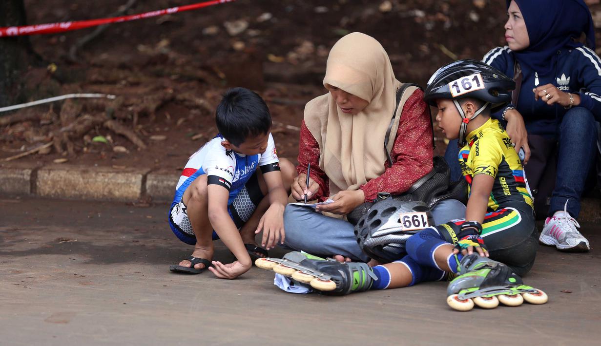 Dua orang Bocah mendengarkan arahan orang tua dalam kejuaraan Invitasi Sepatu Roda DKI Jakarta di Senayan, Jakarta, Minggu (8/11/2015). Kejuaraan ini diikuti sekitar 39 klub seluruh Indonesia. (Bola.com/Nicklas Hanoatubun).