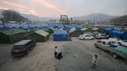 Orang-orang terlihat di tempat penampungan sementara di alun-alun utama di Dahejia, Kabupaten Jishishan, Provinsi Gansu, Barat Laut Tiongkok pada 20 Desember 2023. (PEDRO PARDO/AFP)