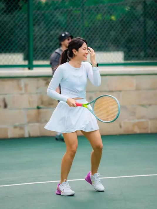 Dian Sastro terlihat memilih mengenakan outfit tenis serba putih. Sport branya ditumpuk dengan atasan lengan panjang, lalu dipadu rok tenis yang juga berwarna putih, dan sneakers putih. [Foto: Instagram/therealdisastr]