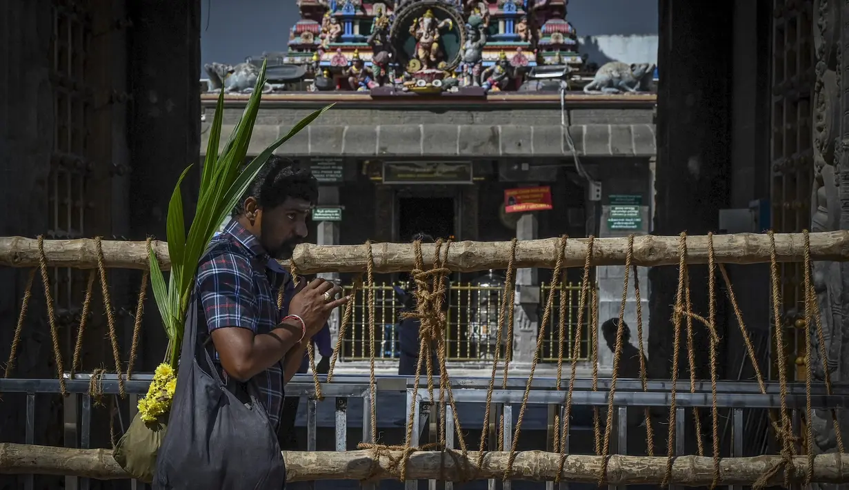 Sebuah barikade ditempatkan di depan kuil Kapaleeshwar, setelah tempat ibadah keagamaan ditutup untuk umum untuk mengekang lonjakan virus corona Covid-19 sesuai arahan pemerintah negara bagian di Chennai (7/1/2022). (AFP/Arun Sankar)