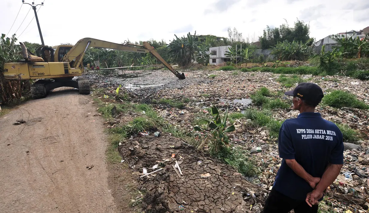 Alat berat saat mengeruk sampah yang memenuhi Kali Pisang Batu, Tarumajaya, Bekasi, Jawa Barat, Rabu (9/1). Lautan sampah yang memenuhi Kali Pisang Batu ini diduga berasal dari aliran kali di wilayah kota Bekasi. (Merdeka.com/Iqbal S. Nugroho)