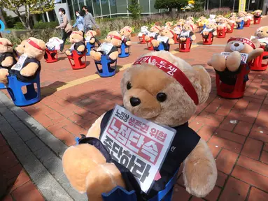 Boneka beruang teddy dipajang untuk memprotes kekerasan terhadap pedagang kaki lima ilegal, di depan kantor distrik Mapo di Seoul, Kamis (24/9/2020). Boneka beruang itu menggantikan pengunjuk rasa untuk menghindari pelanggaran larangan aksi dengan lebih dari 10 orang.  (AP Photo/Ahn Young-joon)