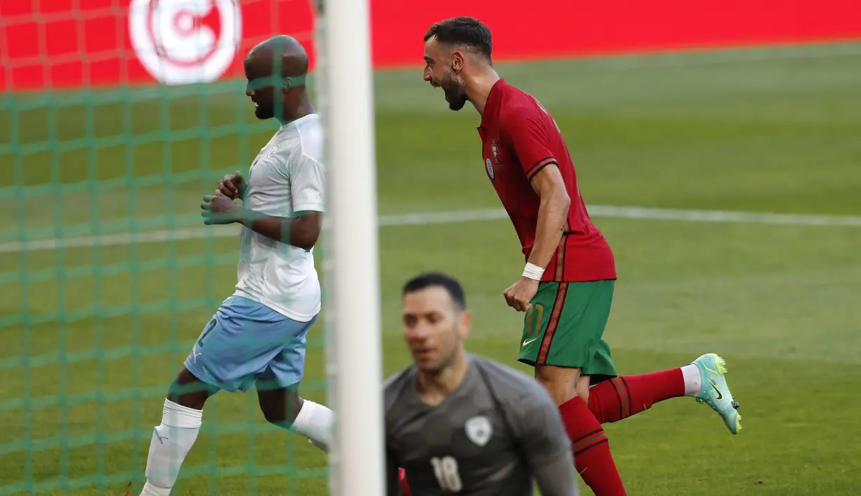 Gelandang Portugal, Bruno Fernandes (kanan) melakukan selebrasi usai mencetak gol pertama Portugal ke gawang Israel dalam laga uji coba menjelang Euro 2020 di Jose Alvalade Stadium, Lisbon, Rabu (9/6/2021). Portugal menang 4-0 atas Israel. (AP/Armando Franca)