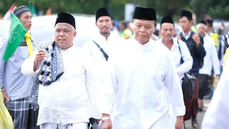 Wakil Ketua MPR RI Hidayat Nur Wahid bersama Ketua PKS Jatim, Irwan Setiawan jalan kaki menuju GOR Delta Sidoarjo untuk menghadiri resepsi puncak 1 Abad NU. (Istimewa).