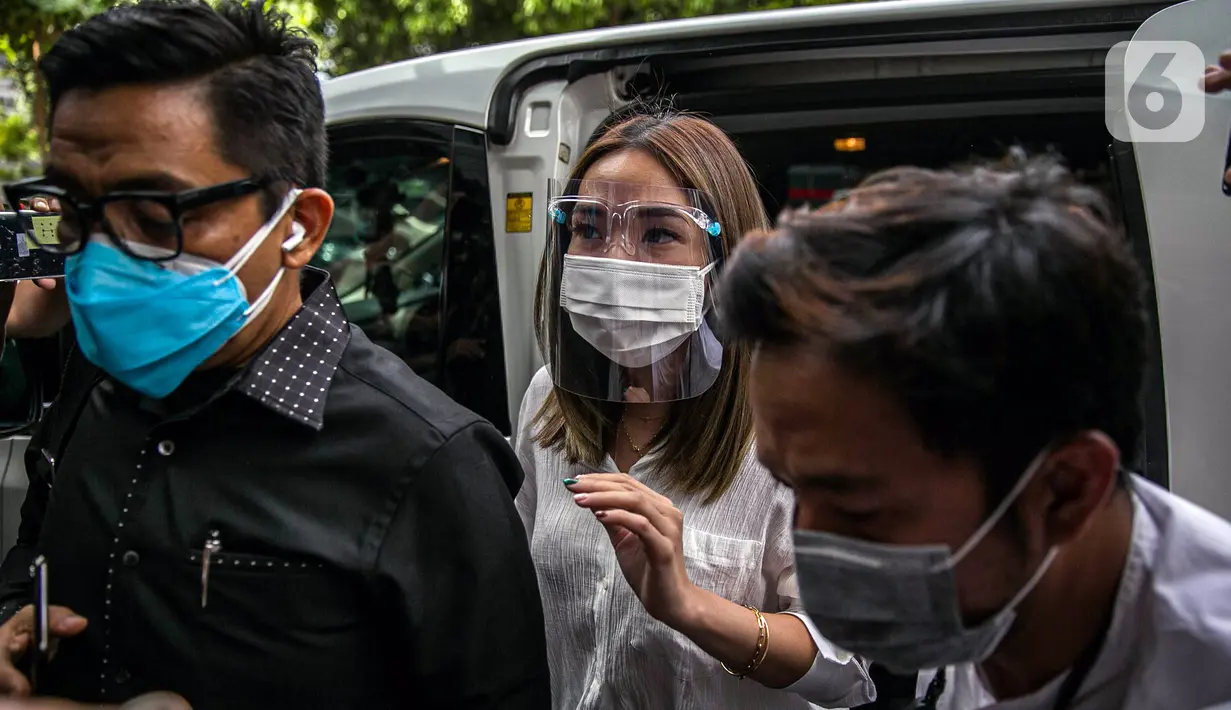 Selebritas Gisella Anastasia atau Gisel (tengah) didampingi pengacaranya tiba di Gedung Ditreskrimsus Polda Metro Jaya, Jakarta, Rabu (23/12/2020). Gisel memakai face shiled dan mulutnya juga tertutup masker putih. (Liputan6.com/Faizal Fanani)