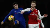 Striker Chelsea, Alvaro Morata berebut bola dengan bek Arsenal, Shkodran Mustafi pada pekan ke-22 Premier League di Emirates Stadium, Rabu (3/1). Arsenal dan Chelsea tampil maksimal hingga laga berakhir penuh drama dengan skor 2-2 (Adrian DENNIS / AFP)
