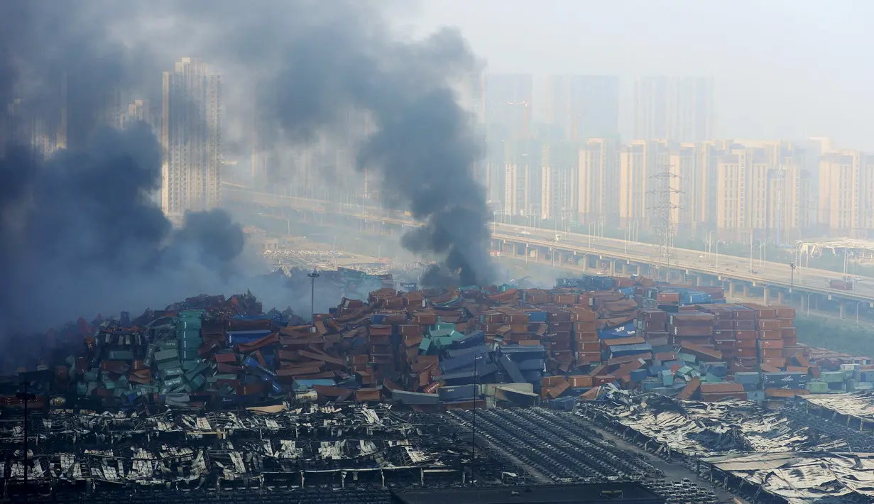 Kepulan asap terlihat membumbung di lokasi ledakan di pelabuhan Kota Tianjin, China, Kamis (13/8/2015). Ledakan yang diperkirakan berkekuatan setara 21 ton TNT ini menewaskan 17 orang dan ratusan lainya terluka. (REUTERS/Stringer CHINA OUT)