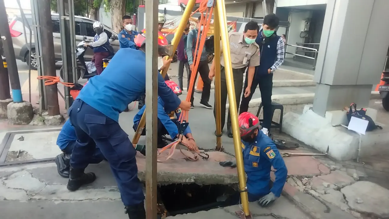 Petugas Damkar DKI Jakarta mengevakuasi kartu ATM di dalam got