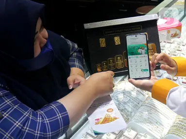 Pegawai PT Bank Syariah Indonesia Tbk (BSI) Cabang Mayestik memberikan penjelasan fitur gadai dan cicil emas di salah satu kios saat Grebek Pasar BSI di Pasar Mayestik, Jakarta (16/12/2021). BSI dorong pertumbuhan pembiayaan gadai dan cicil emas lewat program grebek pasar. (Liputan6.com/HO/Rizky)
