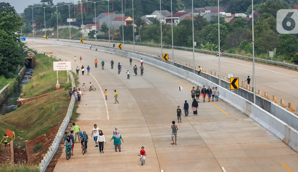 Warga berolahraga sepeda dan berlari pada waktu sore di kawasan pembangunan Tol Serpong Kunciran, Ciputat, Tangerang Selatan, Kamis (25/6/2020). Sebagian warga terlihat tidak mengindahkan protokol kesehatan seperti menggunakan masker dan physical distancing. (Liputan6.com/Fery Pradolo)