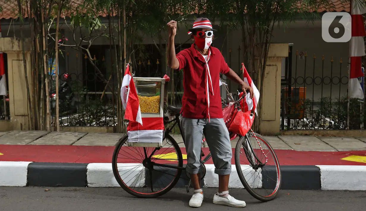 Tarjono (52), pedagang jagung manis, berpose di kawasan Cilandak, Jakarta, Kamis (13/8/2020). Tarjono memodifikasi sepeda yang dipakainya untuk berjualan dengan atribut kemerdekaan dalam rangka memperingati HUT ke-75 RI, serta mengajak warga memasang bendera di rumah. (Liputan6.com/Herman Zakharia)
