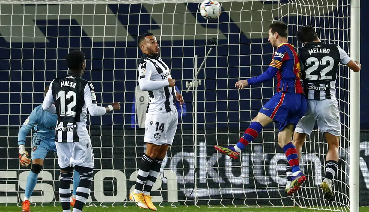 Pemain Barcelona Lionel Messi (kedua kanan) berebut bola udara dengan pemain Levante Gonzalo Melero pada pertandingan La Liga Spanyol di Stadion Camp Nou, Barcelona, Spanyol, Minggu (13/12/2020). Barcelona menang 1-0. (AP Photo/Joan Monfort)