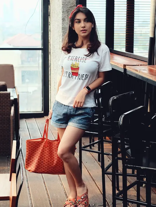 Parasnya yang cantik juga semakin memikat lantaran gaya berbusananya yang sangat kekinian. Seperti yang satu ini, Ibel memakai short pants dengan kaus putih. Makin cantik dengan bandana merahnya. (Instagram/_irishbella_)