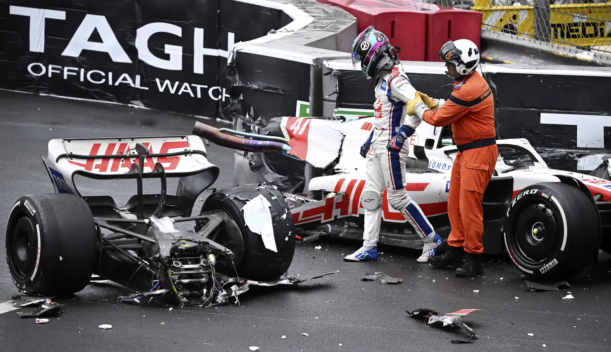 Pembalap Tim Haas, Mick Schumacher dibantu oleh marshall keluar dari mobilnya usai mengalami kecelakaan saat Formula 1 GP Monako yang berlangsung di Circuit de Monaco, Minggu, 29 Mei 2022. (AP/Pool/Christian Bruna)