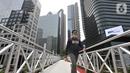 Pejalan kaki melintas di jembatan penyeberangan orang (JPO) yang tidak beratap di jalan Sudirman, Jakarta, Rabu (6/11/2019). Pemprov DKI melalui Dinas Bina Marga mencopot atap JPO Sudirman agar pejalan kaki dapat menikmati pemandangan gedung-gedung pencakar langit. (merdeka.com/Iqbal Nugroho)