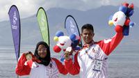 Atlet modern pentathlon, Dea Salsabila Putri (kiri( menunjukan medali usai meraih medali emas di nomor beach triathle individual di Subic, Jumat (6/12/2019) Dea menjadi yang terbaik dengan catatan waktu 00:19:52.73. (Bola.com/M Iqbal Ichsan)