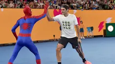 Petenis Swiss Roger Federer (kanan) bertepuk tangan dengan Spider-Man selama Hari Anak-anak menjelang turnamen tenis Australia Terbuka di Melbourne (13/1). (AFP Photo/Paul Crock)