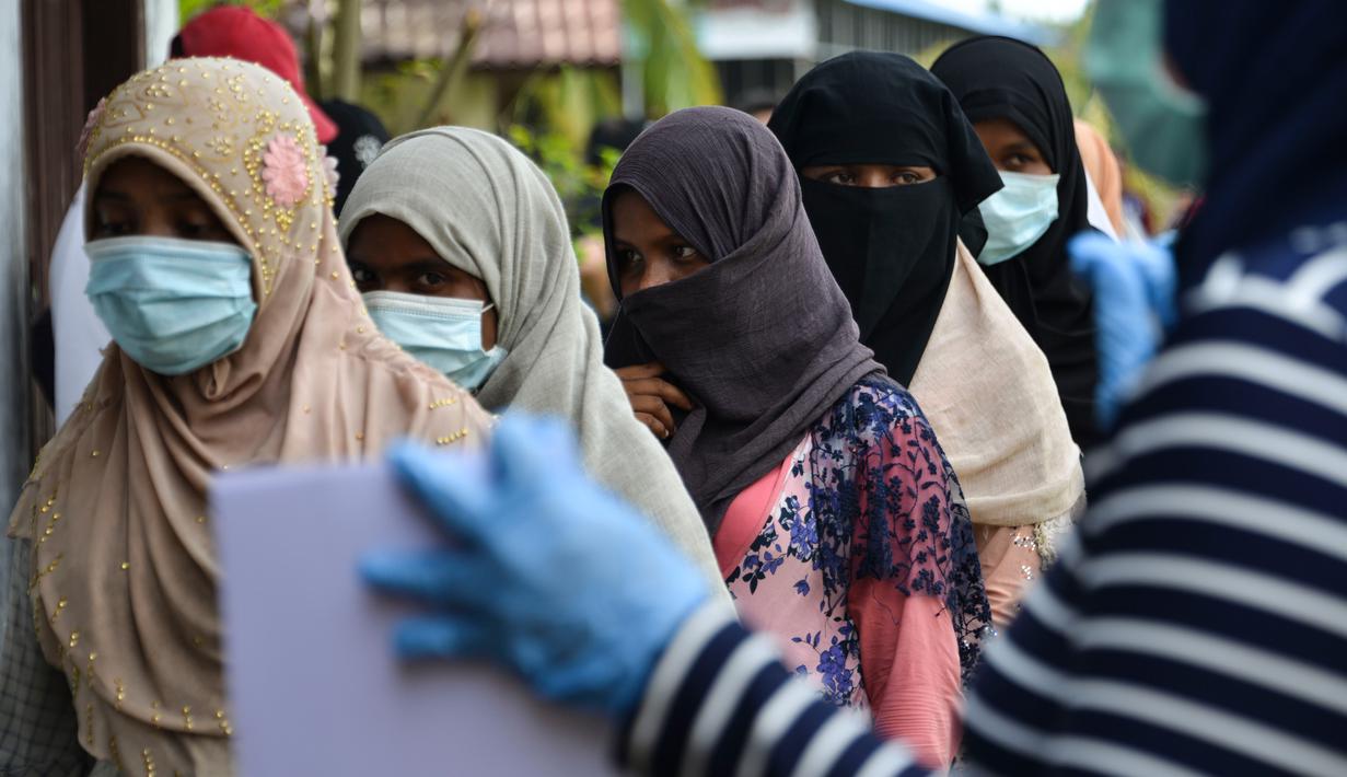Pengungsi Rohingya saat menjalani prosedur identifikasi oleh kepolisian Aceh di pusat penampungan sementara bekas kantor Imigrasi Punteuet di Lhokseumawe, Aceh Utara (26/6/2020). (AFP Photo/CHAIDEER MAHYUDDIN)
