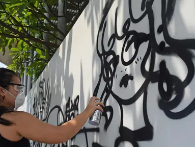 Siswa sedang melukis mural di dinding sekolah Jakarta Intercultural School (JIS), Jakarta, Sabtu (7/4). Kolaborasi antara darbortz dan siswa dilaksanakan dengan tujuan agar siswa memiliki pengalaman langsung berinteraksi. (Liputan6.com/Herman Zakharia)