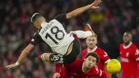 Gelandang Fulham, Andreas Pereira terpelanting saat perebutan bola dengan gelandang Liverpool, Curtis Jones pada laga leg pertama babak semifinal Carabao Cup 2023/2024 di Anfield Stadium, Liverpool, Kamis (11/1/2024) dini hari WIB. (AP Photo/Jon Super)