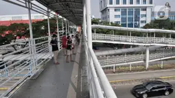 Sejumlah anak menerbangkan layangan dari Jembatan Penyeberangan Orang (JPO) di Jakarta, Kamis (11/6/2020). Minimnya ruang terbuka di sekitar tempat tinggal anak-anak itu menyebabkan mereka terpaksa bermain layang-layang di JPO yang sangat berisiko dan berbahaya. (merdeka.com/Iqbal Nugroho)