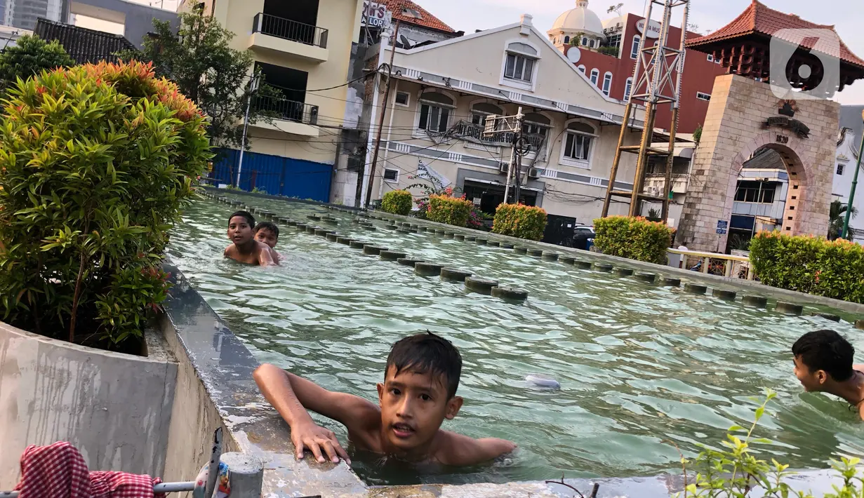 Anak-anak berenang di kolam penghias taman Pasar Baru di Jakarta, Rabu (2/9/2020). Meskipun terdapat larangan, namun sejumlah anak tetap nekat berenang di kolam tersebut sehingga mengganggu ketertiban umum. (Liputan6.com/Immanuel Antonius)