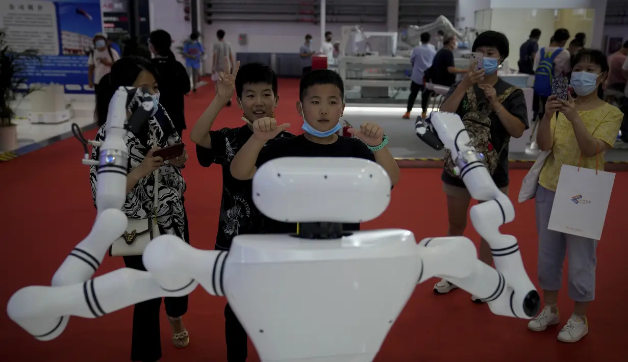 Anak-anak memberi isyarat saat mereka bermain dengan robot buatan China selama Konferensi Robot Dunia di Pusat Konferensi dan Pameran Internasional Yichuang di Beijing, Kamis (18/8/2022). (AP Photo/Andy Wong)