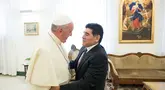Paus Fransiskus (kiri) bersalaman dengan mantan pesepak bola Argentina, Diego Armando Maradona sebelum pertemuan dengan anggota organisasi Scholas Occurentes di Vatikan pada tanggal 4 September 2014. (AFP/Filippo Monteforte)