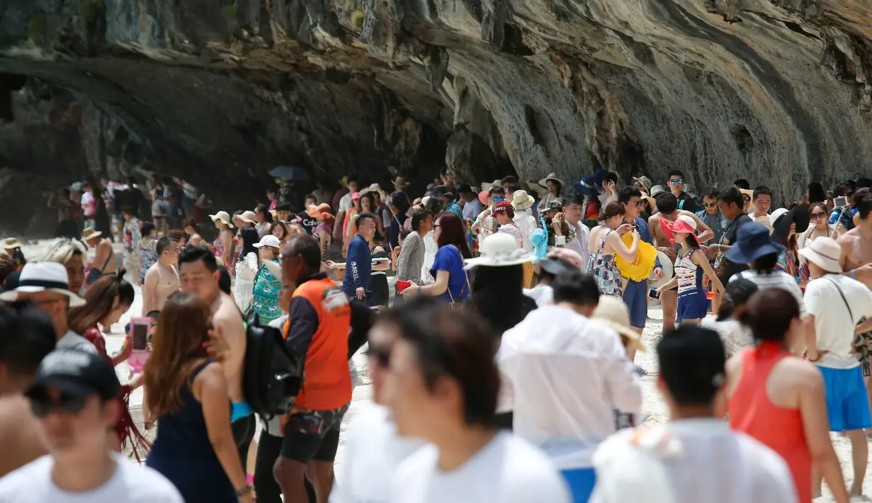 Wisatawan berjalan di sepanjang Maya Bay, pulau Phi Phi Leh, Thailand, Kamis (31/5). Maya Bay akan ditutup untuk memulihkan terumbu karang yang sakit akibat peningkatan suhu serta pencemaran lingkungan oleh pengunjung. (AP Photo/Sakchai Lalit)