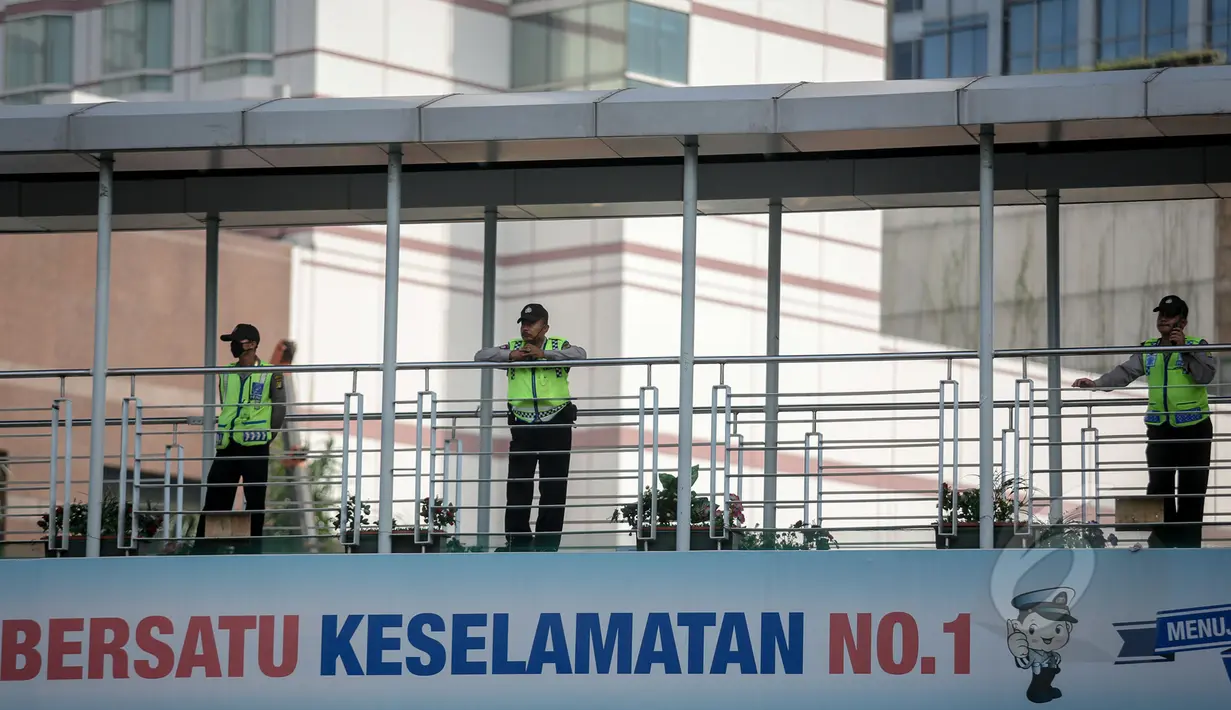 Anggota kepolisian memantau dari atas JPO Bundaran HI dalam gladi lapangan untuk pengamanan peringatan Hari Buruh Internasional atau biasa disebut May Day yang jatuh pada 1 Mei, Jakarta, Jumat (30/4/2015). (Liputan6.com/Faizal Fanani)