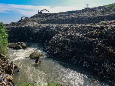Warga memanfaatkan aliran Kali Pesanggrahan yang menyempit untuk mendulang benda-benda logam di kawasan Pasir Putih, Depok, Jawa Barat, Senin (27/4/2026), setelah longsoran sampah dari Tempat Pembuangan Akhir (TPA) Cipayung menutup sebagian badan sungai. (merdeka.com/Arie Basuki)