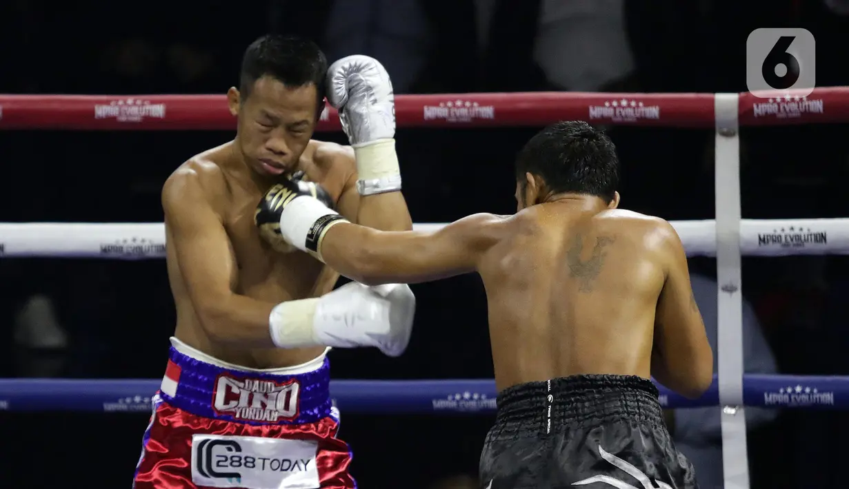 Petinju Indonesia, Daud Yordan (kiri) mendapat pukulan saat melawan Panya Uthok (Thailand) pada laga mempertahankan gelar WBC Asia Boxing Council Silver Super Lightweight di Balai Sarbini, Jakarta, Jumat (1/7/2022). Kedua petinju jual-beli seragan dalam tiga ronde pertama. Duel memanas hingga memasuki ronde keenam. (Liputan6.com/Helmi Fithriansyah)