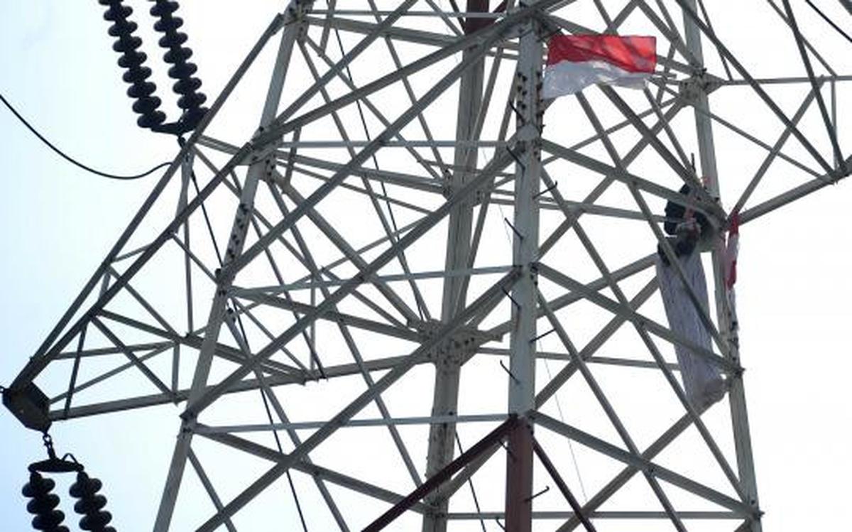 Pria berpakaian pocong di atas tower SUTET