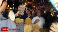 Wali Kota Batu, Dewanti Rumpoko menikmati buah durian di Festival Durian, Kamis (22/3/2018) malam di Pasar Parkiran, Kota Batu. (Ferry/TIMES Indonesia)