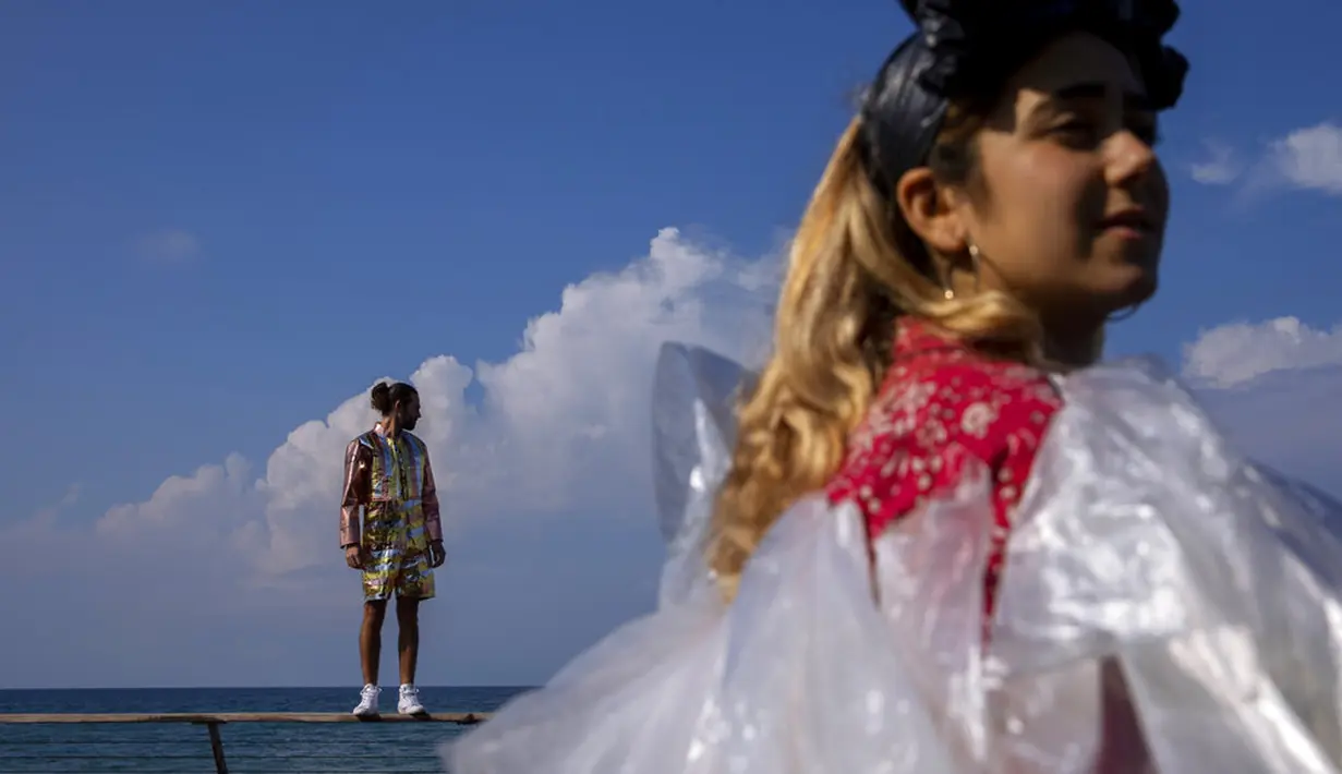 Aktivis lingkungan berpakaian sampah kebanyakan dari plastik dalam unjuk rasa yang disebut Revolusi Mode di Tel Aviv, Israel, 19 November 2021. Aksi ini dilakukan untuk meningkatkan kesadaran iklim. (AP Photo/Oded Balilty)