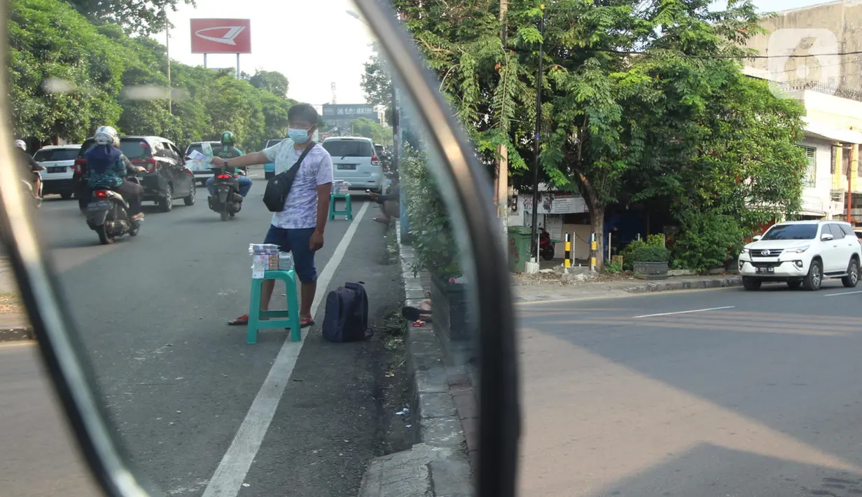 Penjual jasa penukaran uang baru menawarkan uang baru kepada pengguna Jalan Otista Raya di Karawaci, Kota Tangerang, Senin (10/5/2021). Penjual jasa penukaran uang baru musiman tersebut mulai bermunculan menjelang lebaran yang dikenakan tarif jasa sebesar 10 persen. (Liputan6.com/Angga Yuniar)