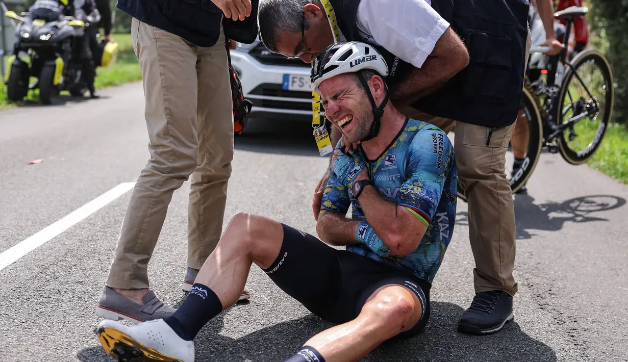 Mark Cavendish dari Inggris meringis kesakitan saat menerima bantuan medis setelah mengalami kecelakaan pada etape kedelapan balap sepeda Tour de France sepanjang 201 kilometer (125 mil) dengan start di Libourne dan finis di Limoges, Prancis, Sabtu (8/7/2023). (Photo by Thomas SAMSON / AFP)