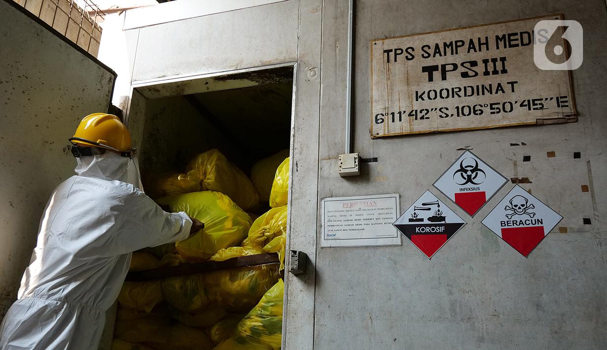 Petugas mengambil limbah medis di TPS untuk proses pembakaran ke incinerator di RSCM Jakarta, Jumat (26/6/2020). Menteri Lingkungan Hidup Siti Nurbaya Bakar menyebutkan volume limbah medis infeksius di seluruh Indonesia hingga 8 Juni 2020 mencapai lebih dari 1.100 ton. (Liputan6.com/Herman Zakharia)
