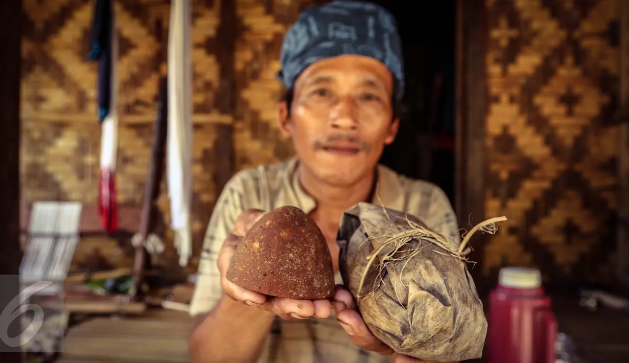 Seorang warga Baduy Luar menunjukan gula aren yang dibungkus daun dan telah dibuka untuk siap dikonsumsi di Kampung Kadu Jangkung, Kabupaten Lebak, Banten (12/05). Gula aren tersebut digunakan sebagai dasar pembuatan makanan. (Liputan6.com/Fery Pradolo)