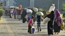 Pengungsi Rohingya berjalan dengan barang-barang mereka untuk dipindahkan ke Pulau Bhasan Char di Chattogram, Bangladesh, Jumat (29/1/2021). Kelompok HAM menyerukan agar Bangladesh menghentikan relokasi ribuan pengungsi Rohingya ke Pulau Bhasan Char. (AP Photo/Azim Aunon)