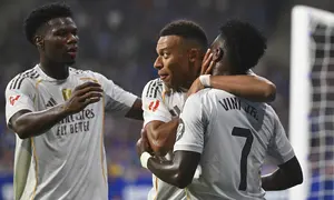Kylian Mbappe dari Real Madrid (tengah) mendapat ucapan selamat dari rekan-rekannya, Vinicius Junior (kanan) dan Aurelien Tchouameni, setelah mencetak gol dalam laga La Liga antara Real Oviedo dan Real Madrid di Stadion Carlos Tartiere, Oviedo, Spanyol, Minggu, 24 Agustus 2025. (AP Photo/Miguel Oses)