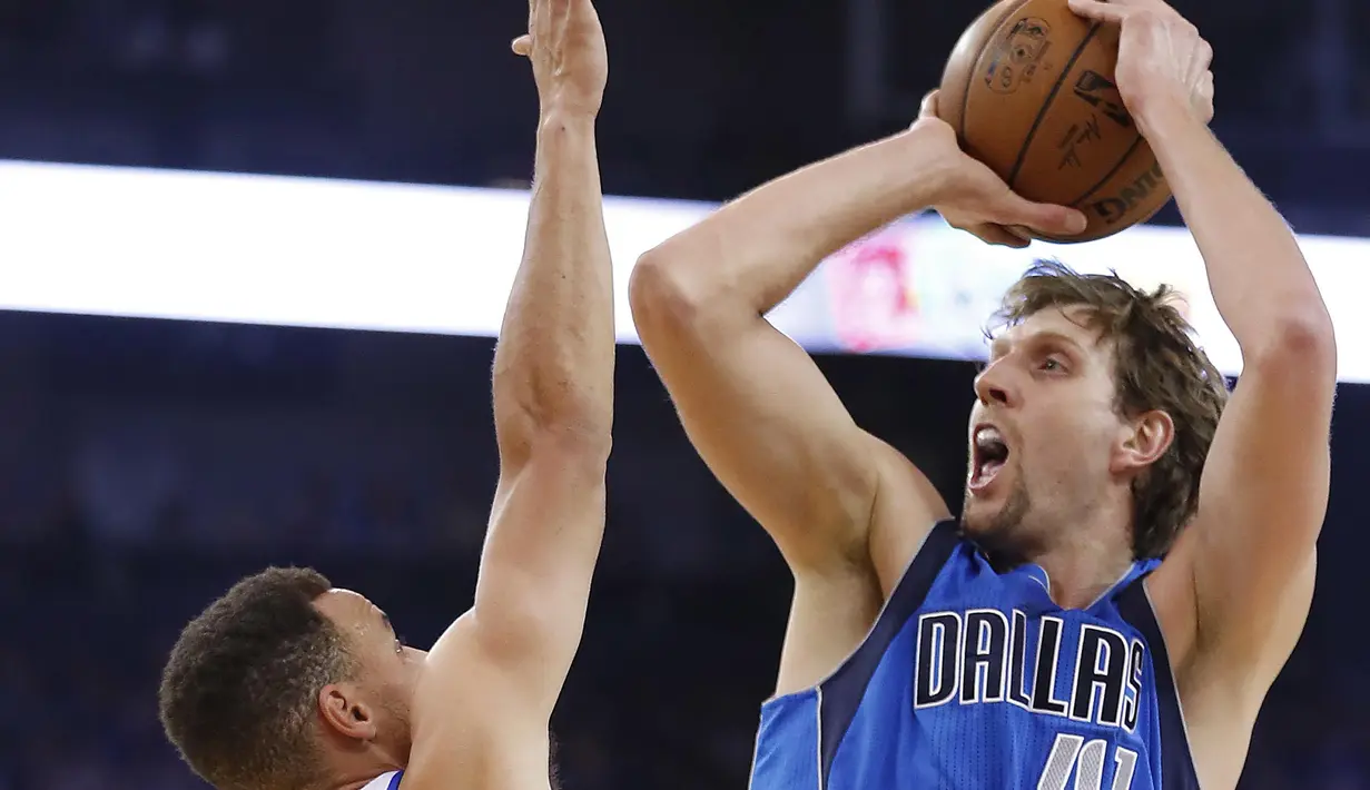 Pemain Dallas Mavericks, Dirk Nowitzki #41 melakukan tembakan saat dibayangi pemain Golden State Warriors, Stephen Curry #30 pada laga NBA basketball game  di Oakland, California, (30/12/2016). Warriors menang 108-99. (AP/Tony Avelar)