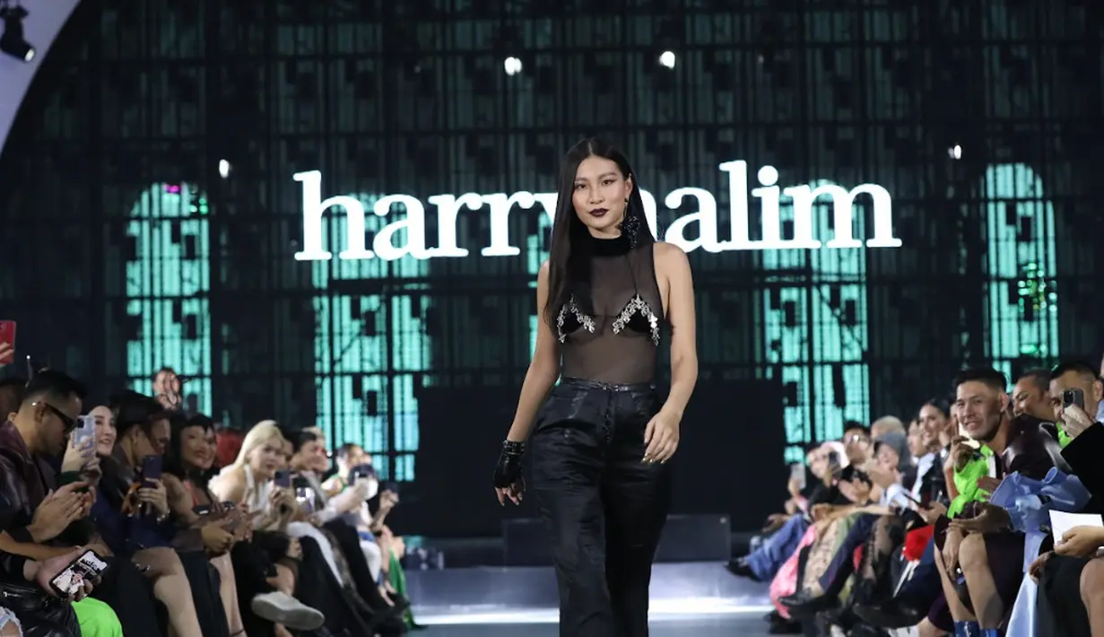 Patricia Gouw tampil berani mengenakan atasan transparan berpadu dengan bra mini hitam. Outfit beraninya dipadukan dengan celana hitam dengan aksen ruffle di bagian bawah [dok. Harry Halim]